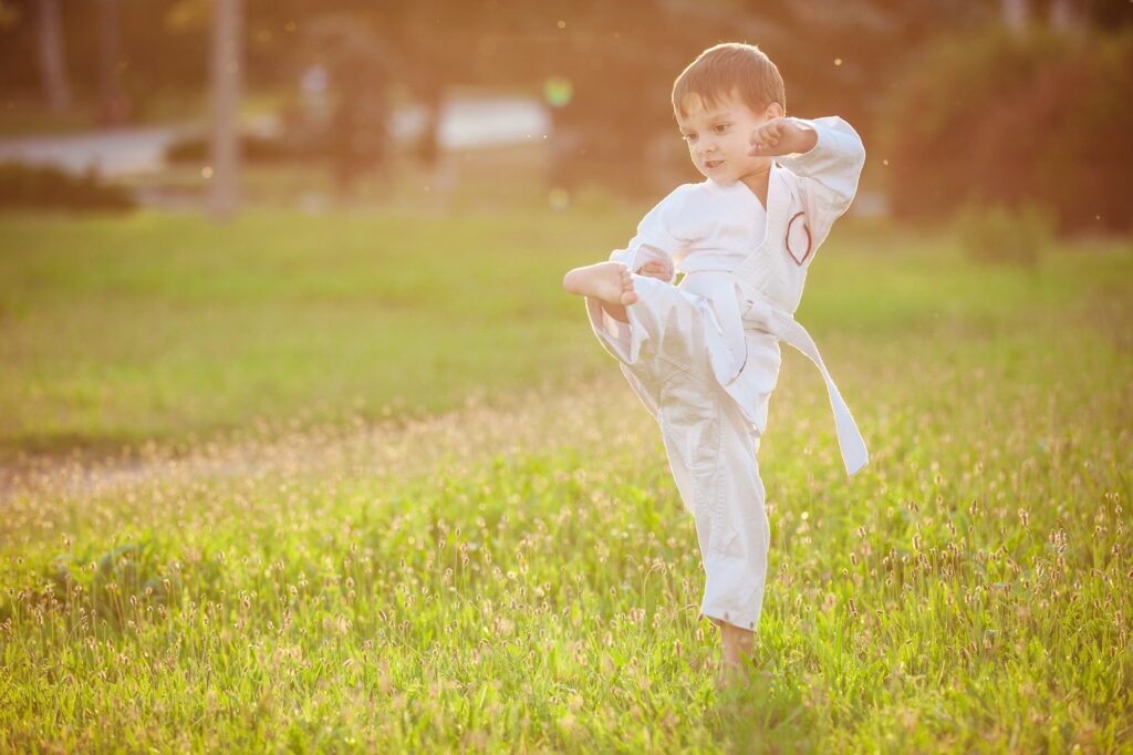 Preschool boy practicing karate outdoors